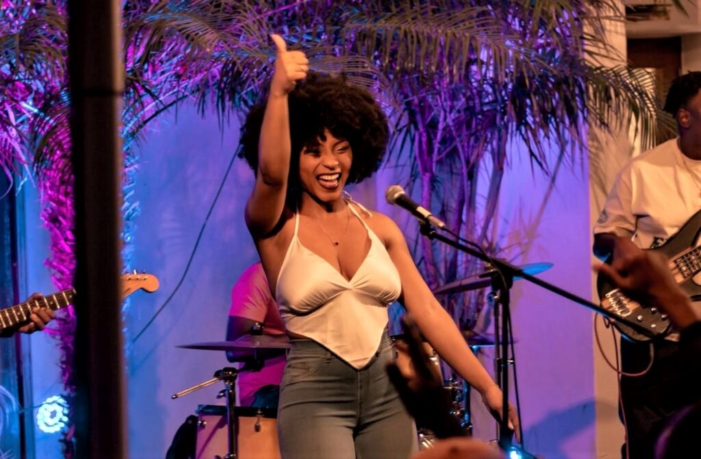 A artista TMRS AwaGe em palco durante uma atuação musical
